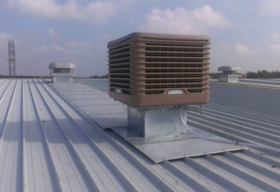 Close up of an evaporative cooling unit on an industrial roof.