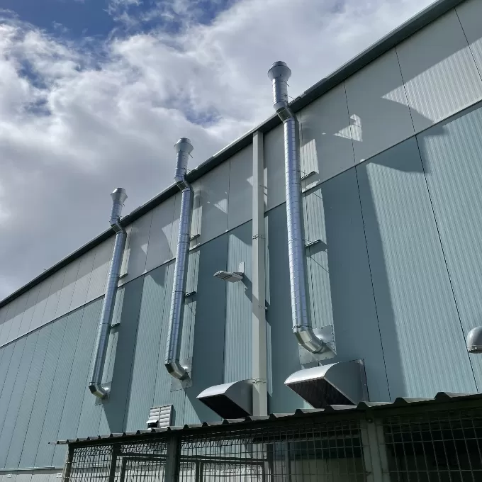 Ventilation pipes outside of a industrial warehouse.