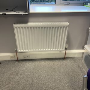 heating system upgrade depicted with a new system radiator and connecting pipework