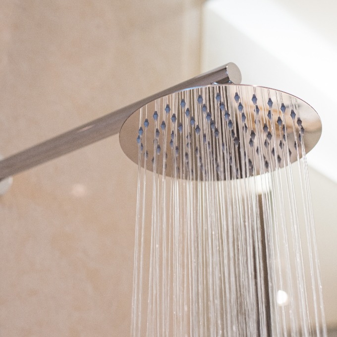 overhead ceiling shower faucet turned on.