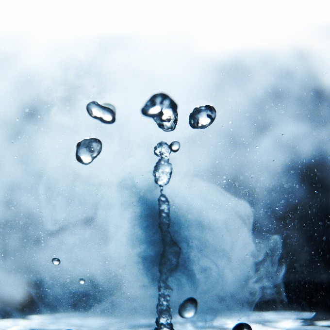 Boiling water splashes with steam on a black background