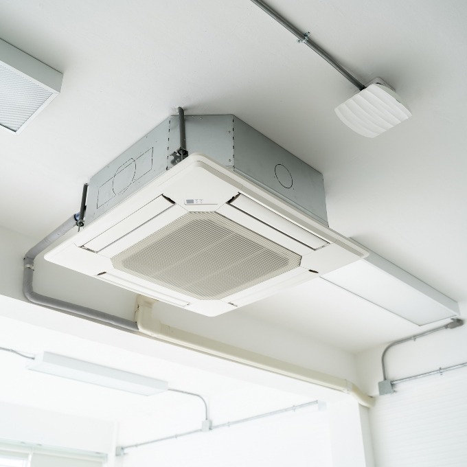 Split-type air conditioning unit hanging on the white ceiling