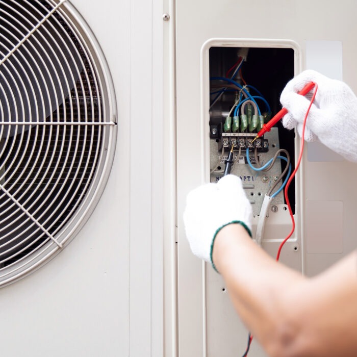 An engineer conducting maintenance services on an air conditioning unit