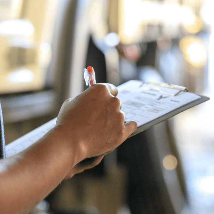 Man holding clipboard and pen completing an inspection of a commercial premises.